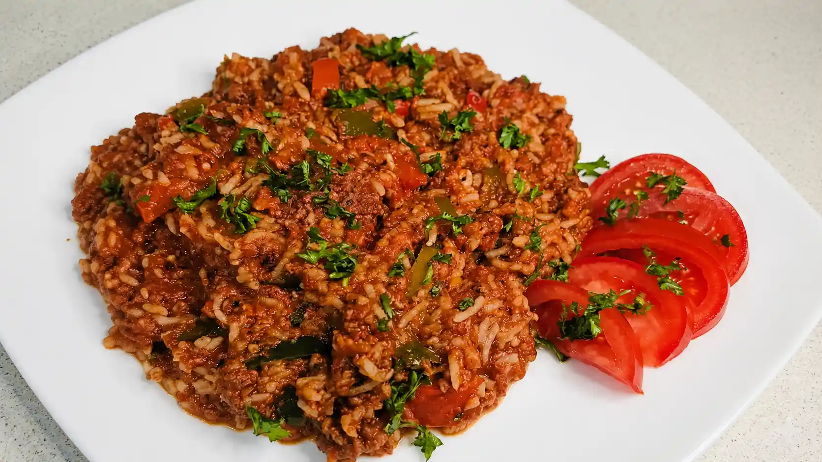 rice dinner with a side of tomatoes on white plate
