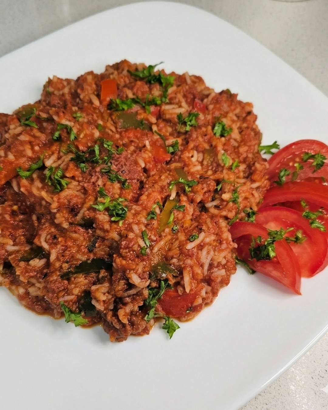 rice dinner with a side of tomatoes on white plate