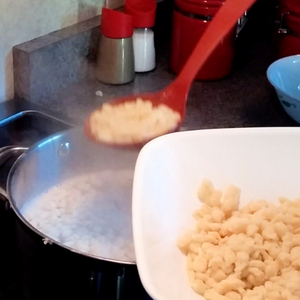Using a slotted spoon, scoop the spätzle out of the water Using a slotted spoon, scoop the spätzle out of the water