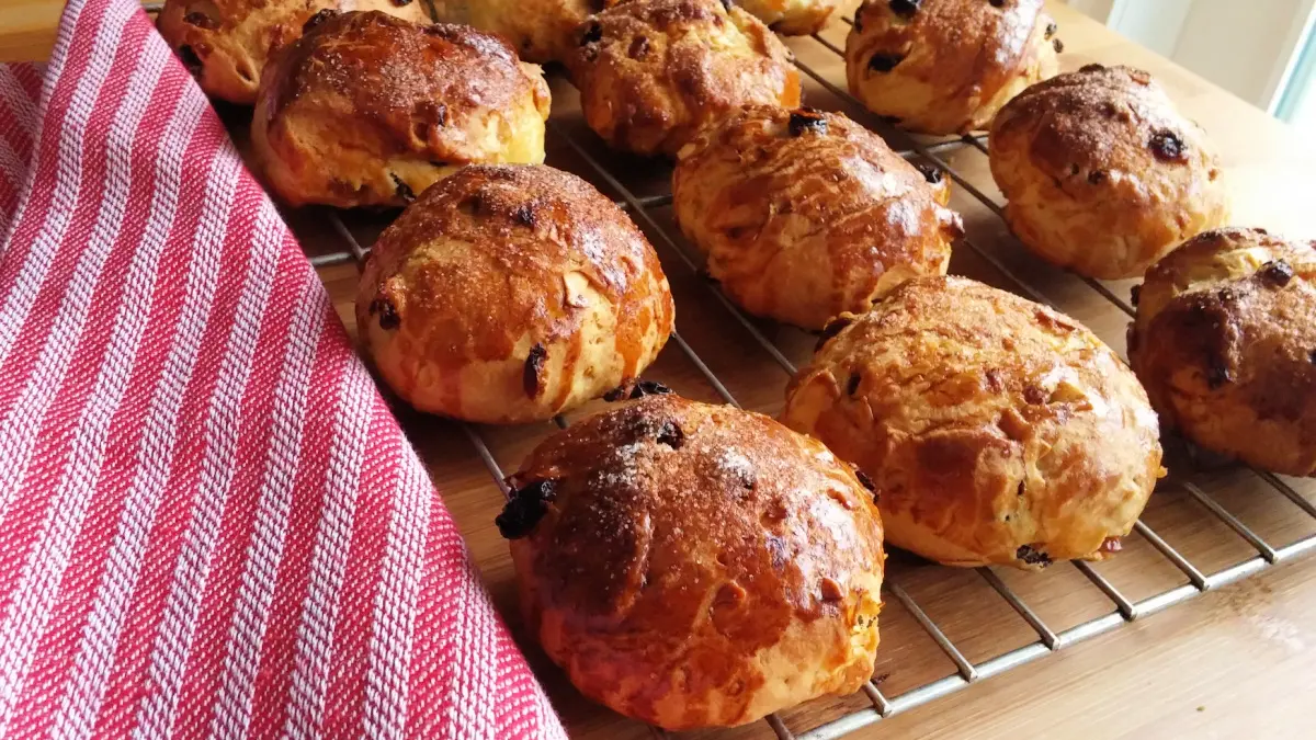 Freshly baked German raisin buns (Rosinenbrötchen) cooling on a wire rack