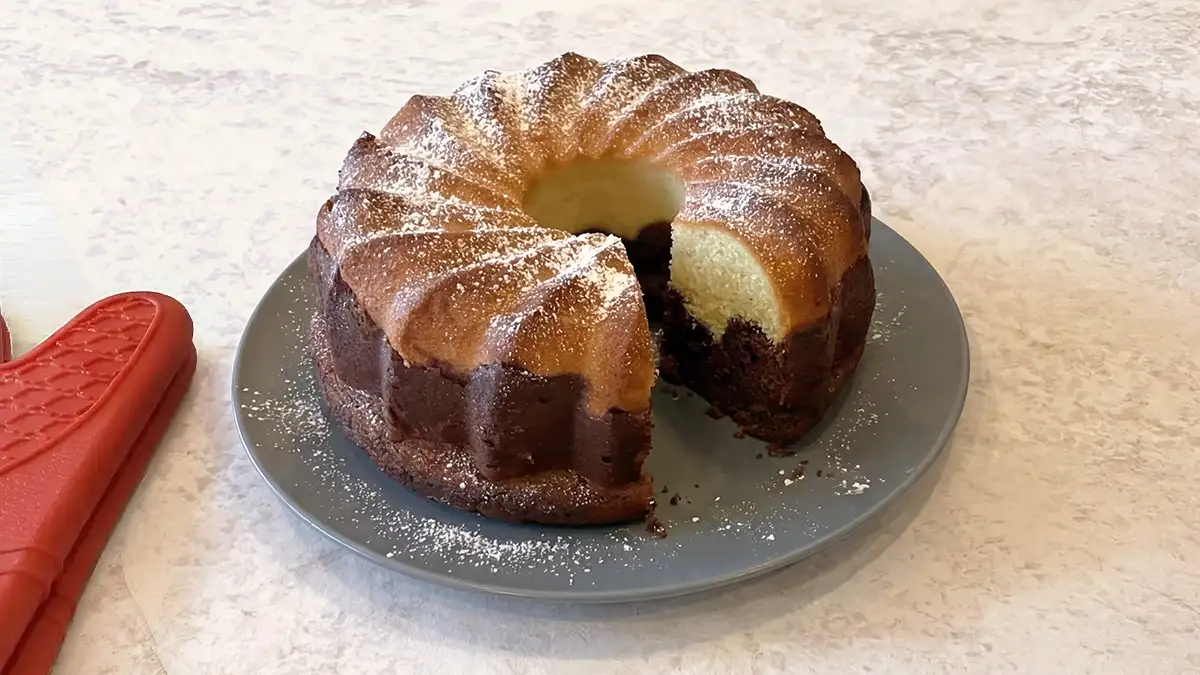 Vegan marble cake like Oma’s German Marmorkuchen dusted with powdered sugar on a plate
