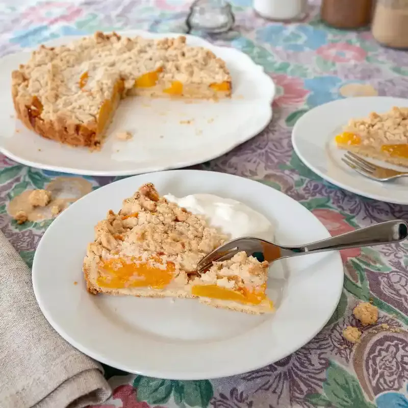 This German streusel fruit tart, Obstkuchen mit Streusel, uses either fresh or canned fruit, such as apricots, peaches, cherries. A delicious treat, just like Oma bakes.