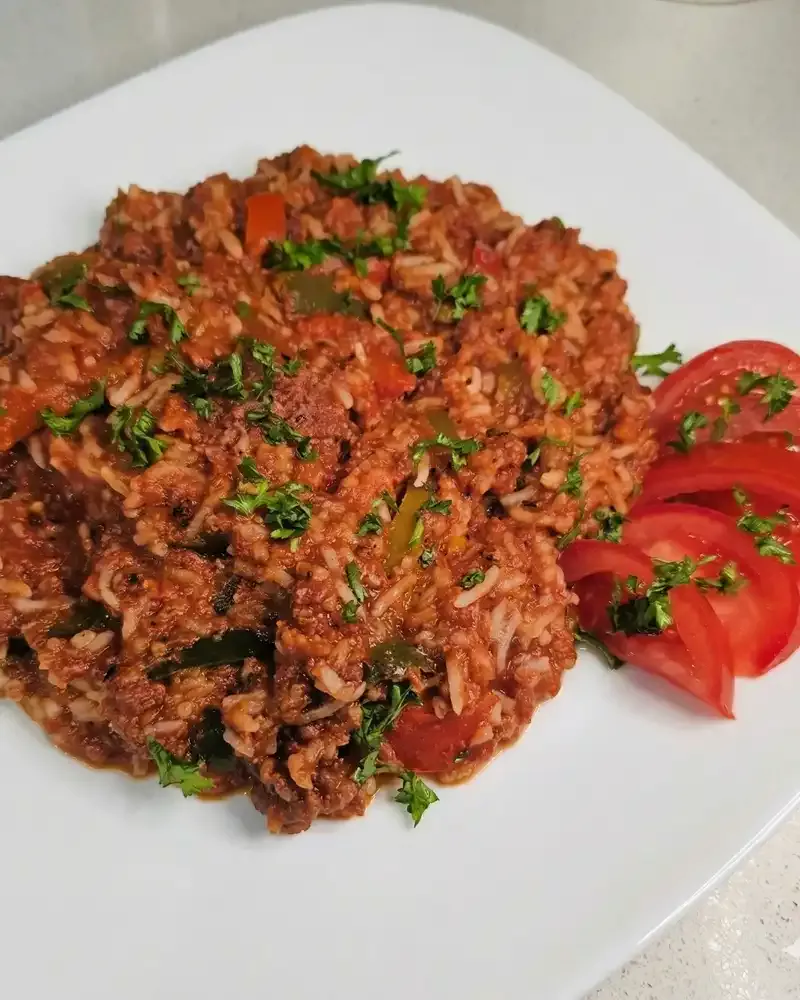 rice dinner with a side of tomatoes on white plate