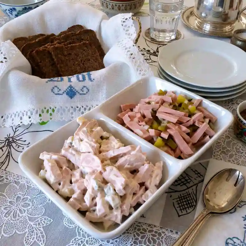 German Wurstsalat sausage salad with sliced bologna, served alongside creamy Fleischsalat